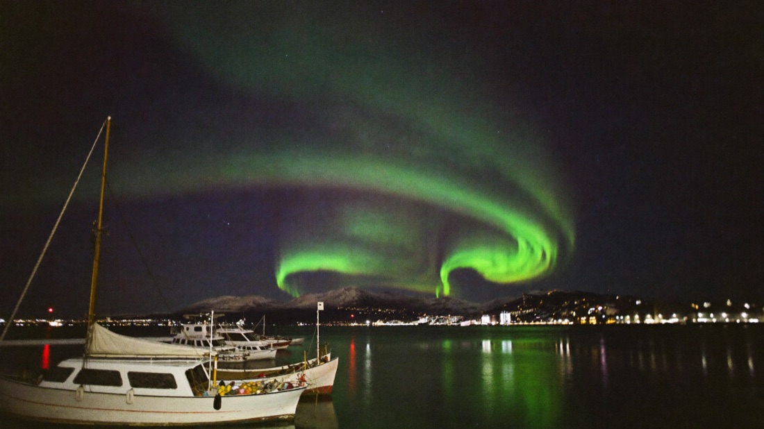 Aurora borealis over Reykjavík harbor at night